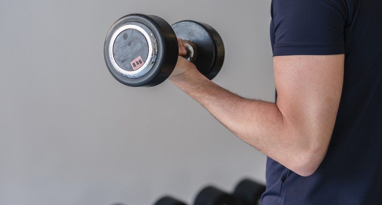 Male doing weights at a gym.